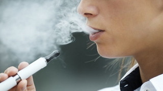 Foto: Eine Frau raucht eine E-Zigarette