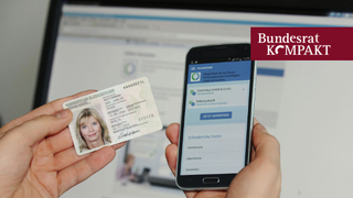Eine Person hält in der linken Hand einen Personalausweis und in der rechten Hand ein Smartphone zur Identifikation.